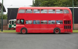 Bus anglais rouge à impériale d'époque pour transporter les invités d'un mariage
